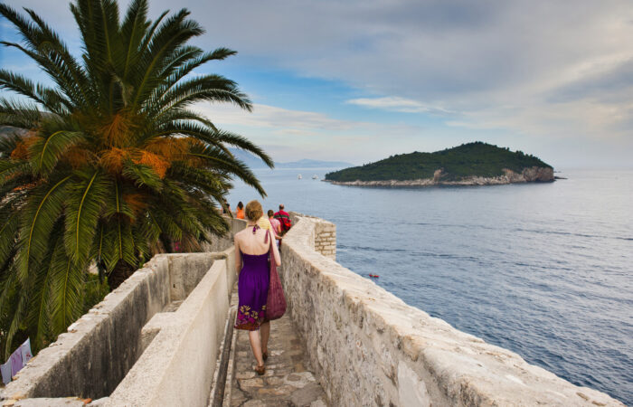 Photo of a tourist walking on Dubrovnik City Walls, Dubrovnik Old Town, Croatia